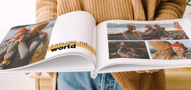 Woman holding an open photobook showing photos of friends celebrating the 4th of July.