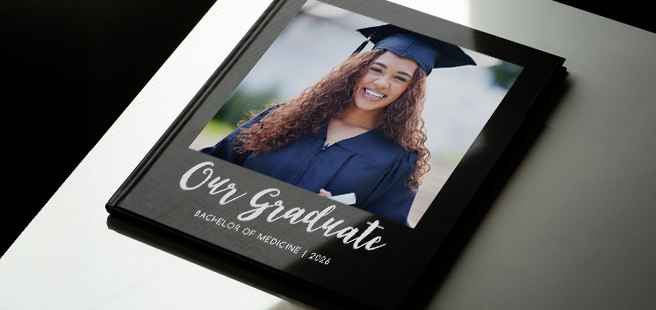 Closed photobook showing photos of a son and father on the cover that reads 'my dad is my superhero'.
