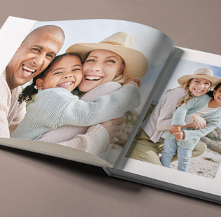 Open book showing photos of mom, dad and daughter outside.