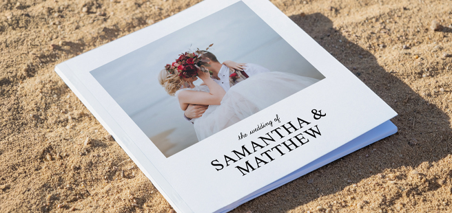 Open layflat photobook showing a photo of a couple on a mountain that stretches across the entire book.