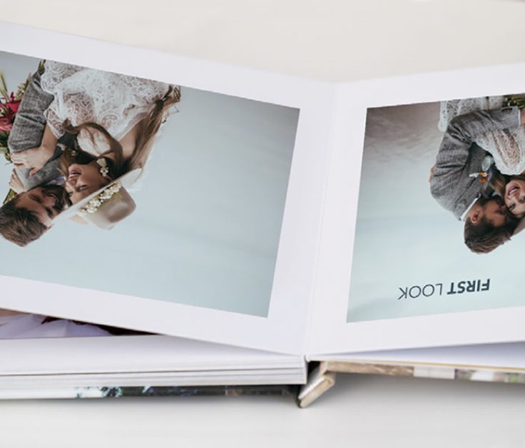 Open layflat photobook with photos of a boho couple for a wedding