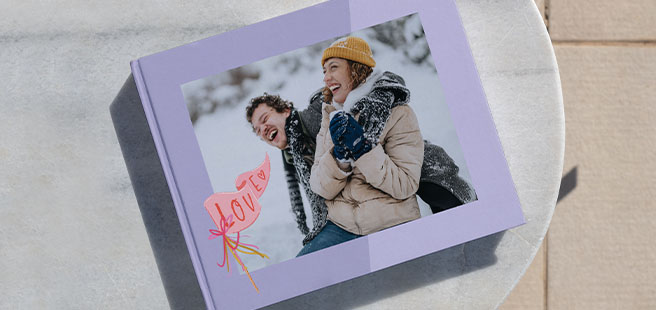 Open layflat photobook showing a photo of a couple on a mountain that stretches across the entire book.