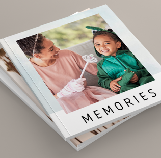 Stack of 3 closed soft photobooks. Top book shows a photo of Mom and son dressed up in costume that reads 'Memories'.