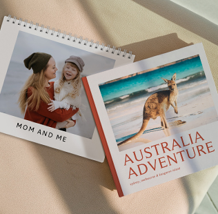 Stack of 3 closed soft photobooks. Top book shows a photo of Mom and son dressed up in costume that reads 'Memories'.