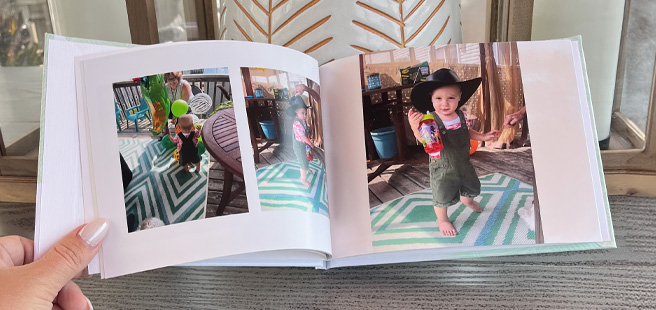 Woman holding open classic photobook showing photos a child